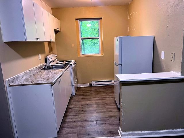 1 Bedroom Apartment at Superior Hill #1G, East Cleveland OH — A kitchen with white cabinets and appliances.