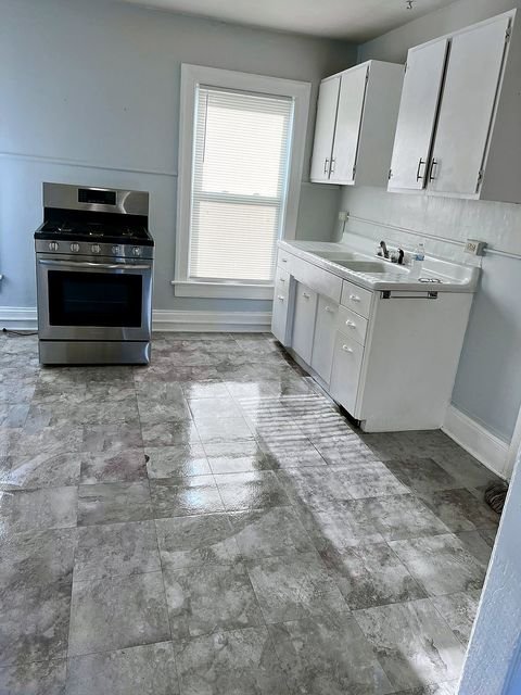 2 Bedroom Apartment at 51 Cotter #4, Akron OH — A kitchen with white cabinets and stainless steel appliances.