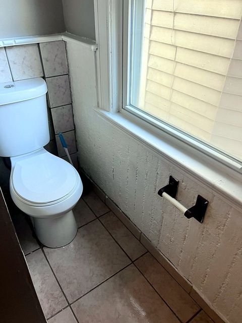 2 Bedroom Apartment at 51 Cotter #4, Akron OH — A white toilet is next to a window with blinds in a bathroom.