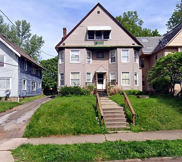 2 Bedroom Apartment at 51 Cotter #4, Akron OH — A three-story house with stairs leading to the front entrance.