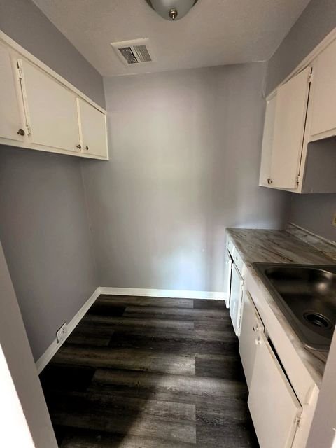 1 Bedroom Apartment at Allen House #105, Cleveland OH — A kitchen with white cabinets and gray walls.