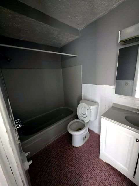 1 Bedroom Apartment at Allen House #105, Cleveland OH — A bathroom with a bathtub, toilet, and vanity.