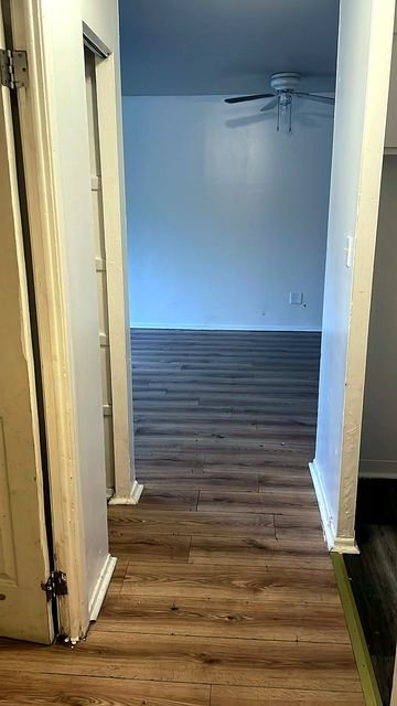 1 Bedroom Apartment at Allen House #105, Cleveland OH — Hallway with wood-look flooring and white walls.