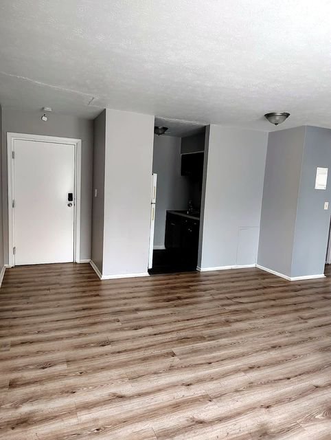 2 Bedroom Apartment at Allen House #208, Cleveland OH — An empty living room with a kitchen area visible.