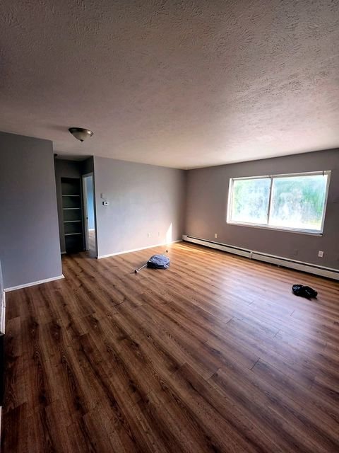 2 Bedroom Apartment at Allen House #208, Cleveland OH — A living room with wood-look flooring, white walls, and a window.