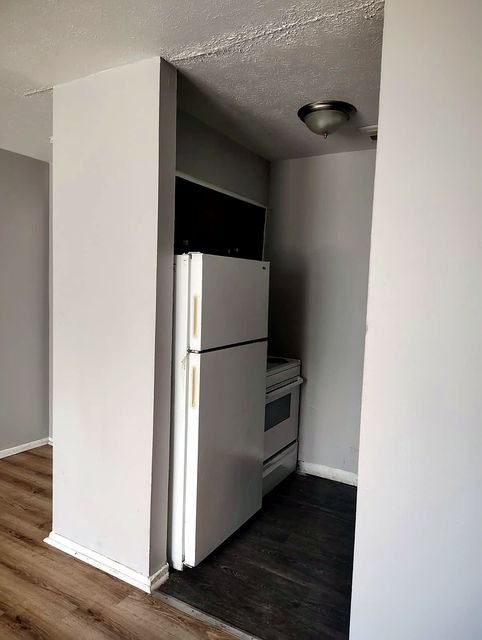 2 Bedroom Apartment at Allen House #208, Cleveland OH — A kitchen with a refrigerator, stove, and upper cabinets.