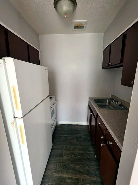2 Bedroom Apartment at Allen House #208, Cleveland OH — A kitchen with white appliances and brown cabinets.