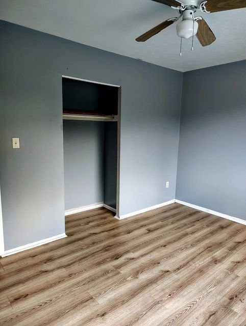 2 Bedroom Apartment at Allen House #208, Cleveland OH — Empty bedroom with gray walls, wood-look flooring, and a ceiling fan.
