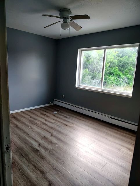 2 Bedroom Apartment at Allen House #208, Cleveland OH — Bedroom with gray walls, wood-look flooring, and a ceiling fan.