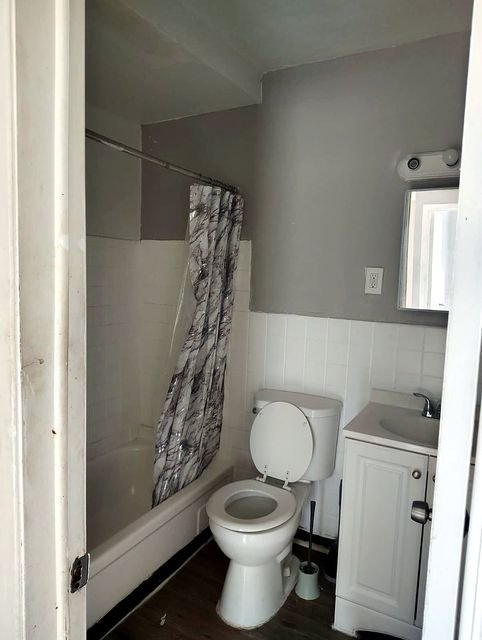 2 Bedroom Apartment at Allen House #208, Cleveland OH — A bathroom with a toilet, bathtub, and vanity.