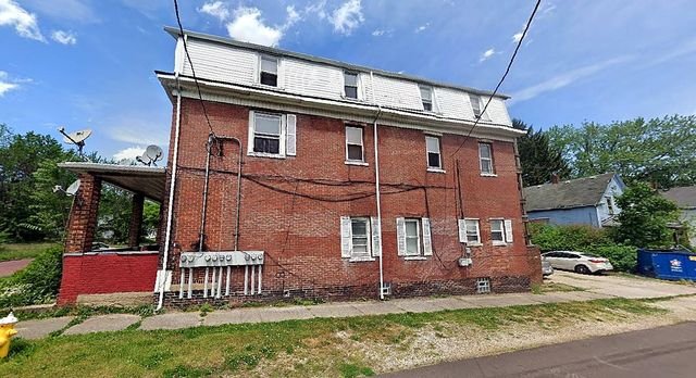 1 Bedroom Apartment at Chittenden #7, Akron OH — A three-story brick building with a porch and white trim.