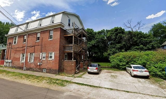 1 Bedroom Apartment at Chittenden #7, Akron OH — A three-story brick apartment building with cars parked in the driveway.