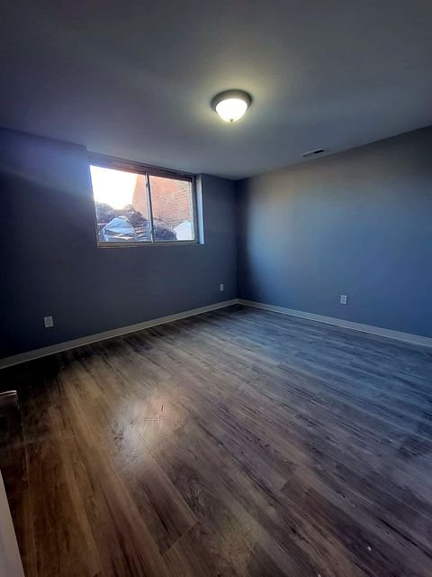 3 Bedroom Apartment at Dayton Apartments #1804 - Unit A, Dayton OH — Empty living room with gray walls and wood-look flooring.