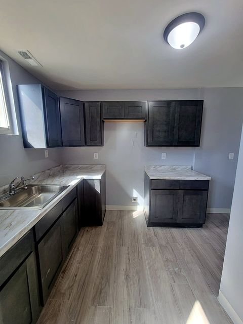 3 Bedroom Apartment at Dayton Apartments #1804 - Unit A, Dayton OH — A kitchen with dark cabinets and white countertops.