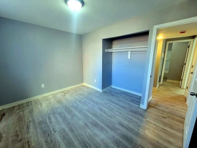 3 Bedroom Apartment at Dayton Apartments #1804 - Unit A, Dayton OH — Bedroom with gray walls, wood-look flooring, and closet.