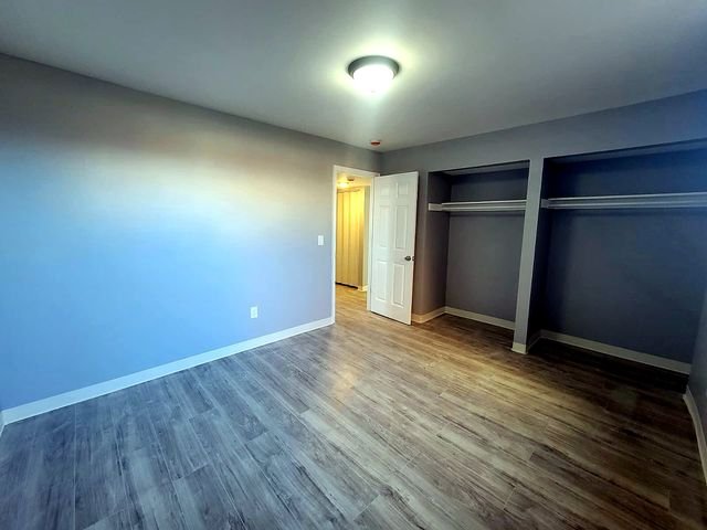 3 Bedroom Apartment at Dayton Apartments #1804 - Unit A, Dayton OH — Bedroom with gray walls, wood-look flooring and built-in closet.