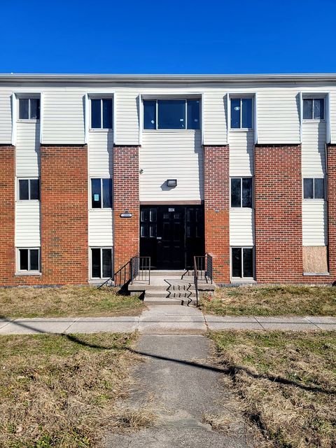 3 Bedroom Apartment at Dayton Apartments #1804 - Unit A, Dayton OH — A three-story brick apartment building with white siding and black doors.