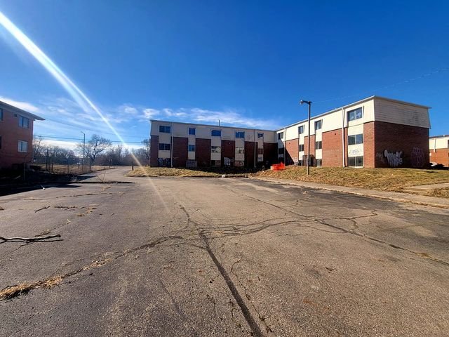 3 Bedroom Apartment at Dayton Apartments #1804 - Unit A, Dayton OH — Three brick apartment buildings are visible across an empty paved area.