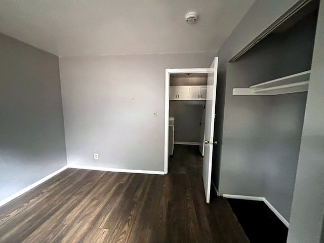 1 Bedroom Apartment at Grovewood #2, Cleveland OH — Bedroom with gray walls, wood floors, and closet.
