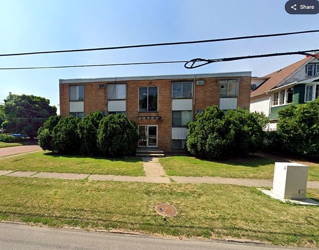1 Bedroom Apartment at Grovewood #2, Cleveland OH — A three-story brick apartment building with landscaping and power lines.