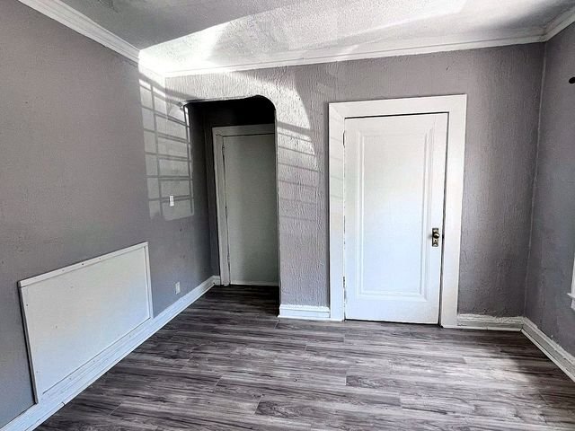 1 Bedroom Apartment at Linn #9, Cleveland OH — A living room with gray walls, wood-look flooring, and two white doors.
