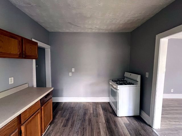 2 Bedroom Apartment at Medellin #1, Cleveland OH — A kitchen with wood cabinets, a gas stove, and laminate flooring.