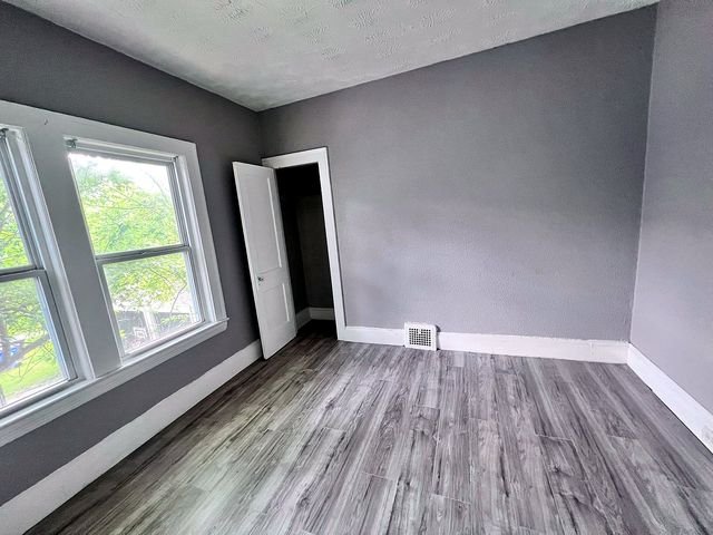 2 Bedroom Apartment at Medellin #1, Cleveland OH — Empty bedroom with gray walls, wood-look flooring, and a window.