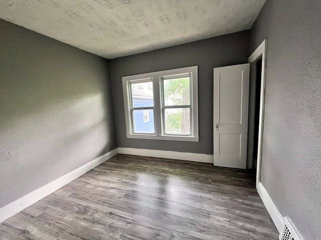 2 Bedroom Apartment at Medellin #1, Cleveland OH — Empty bedroom with gray walls, wood-look flooring, and a window.