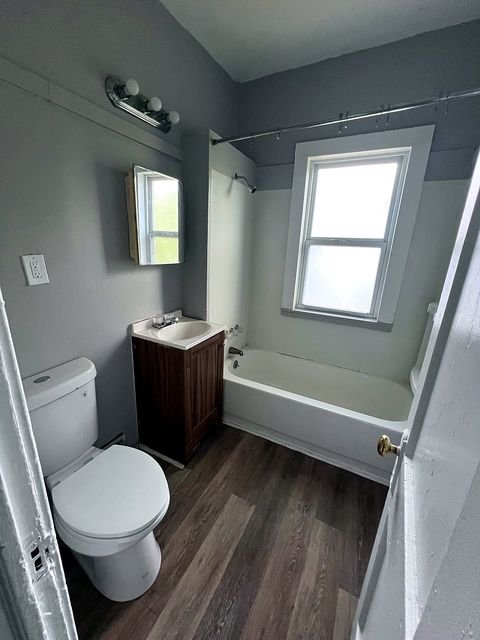 2 Bedroom Apartment at Medellin #1, Cleveland OH — A bathroom with a toilet, bathtub, vanity, and window.