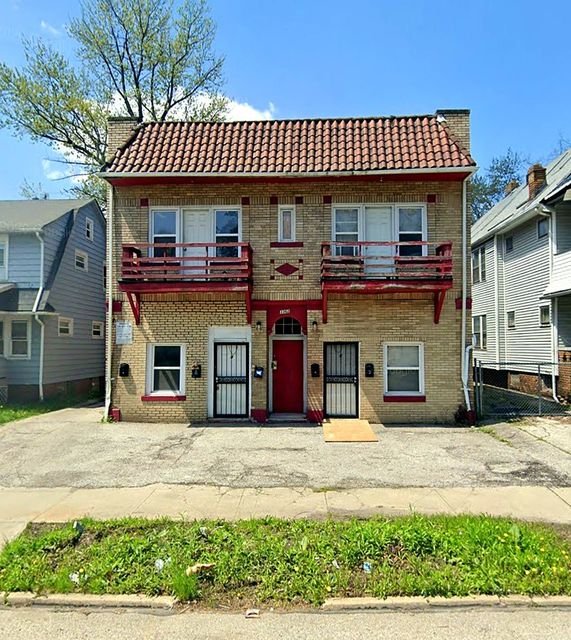 2 Bedroom Apartment at Medellin #1, Cleveland OH — A three-story brick building with red trim and a terracotta roof.