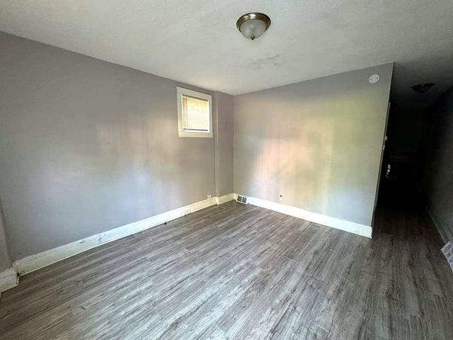 1 Bedroom Apartment at Medellin #4, Cleveland OH — A view of an empty living room with gray walls and wood-look flooring.
