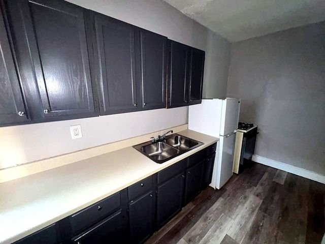 1 Bedroom Apartment at Medellin #4, Cleveland OH — Kitchen with dark cabinets and stainless steel sink.