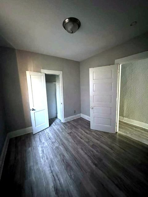 1 Bedroom Apartment at Medellin #4, Cleveland OH — Bedroom with wood-look flooring and two white doors.