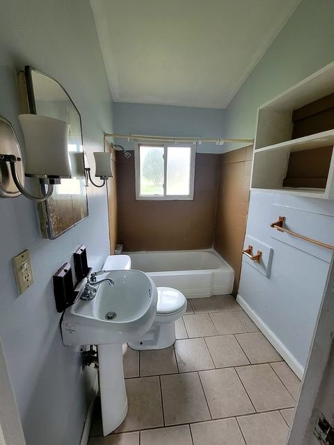 2 Bedroom Apartment at Thurston #1325, Akron OH — A bathroom with a pedestal sink, toilet, bathtub and window.